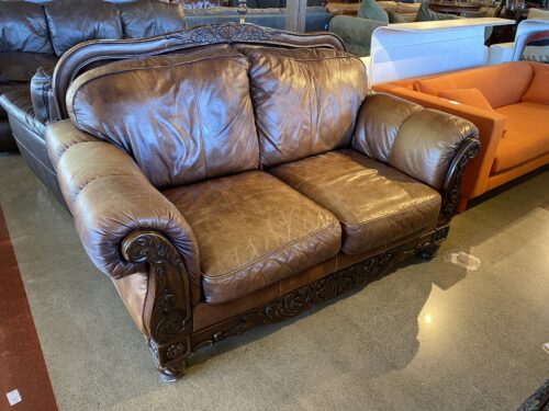 Ornate Brown Leather Loveseat with Rolled Arms and Carved Details