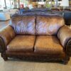 Ornate Brown Leather Loveseat with Rolled Arms and Carved Details