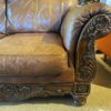 Ornate Brown Leather Loveseat with Rolled Arms and Carved Details