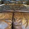 Ornate Brown Leather Loveseat with Rolled Arms and Carved Details