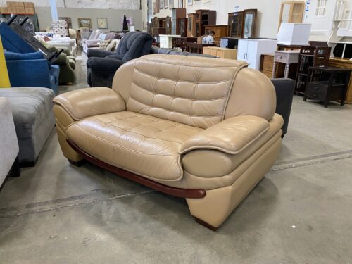 Smiling Red Wood on Tan Leather Loveseat