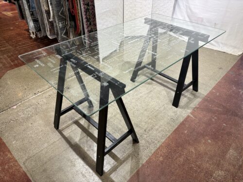 Glass Table with "Love" in Various Languages and a black Sawhorse Base