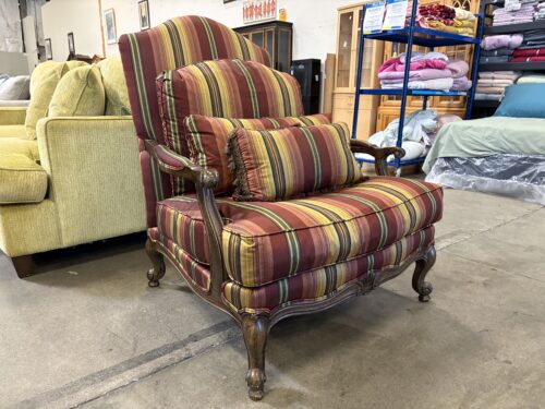 Vintage Carved Wood Accent Chair with Striped Upholstery and Decorative Pillows