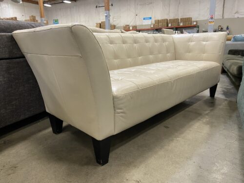 Vintage Ivory Leather Tufted Sofa with Flared Arms and Dark Wooden Legs